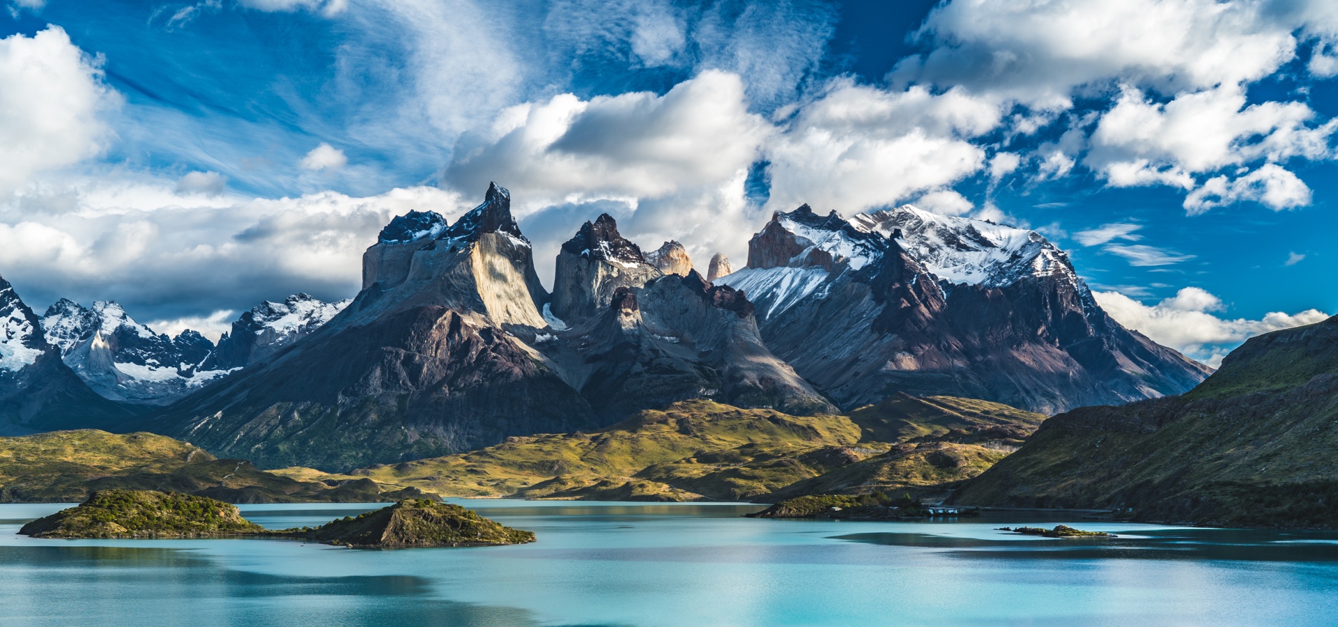 Striking view of the mountains in Torres del paine National Park in Chile, against a blue sky.