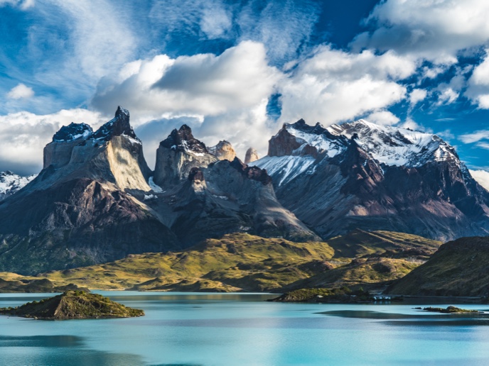 Striking view of the mountains in Torres del paine National Park in Chile, against a blue sky.