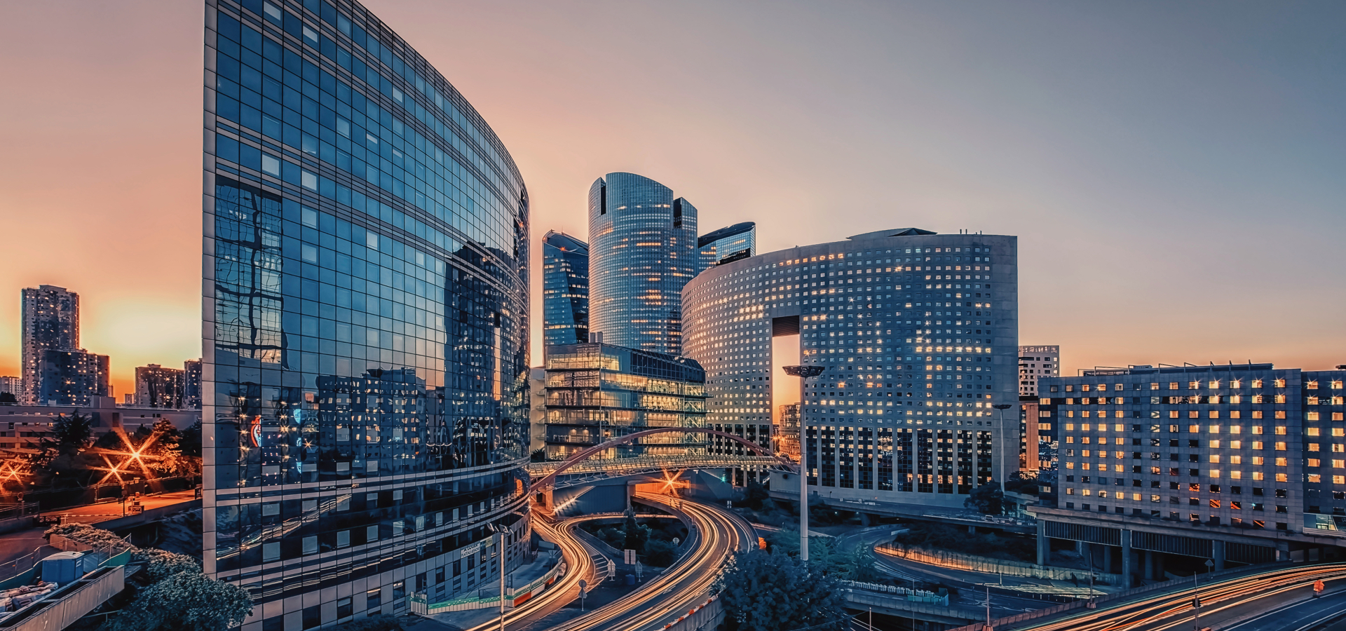 Business district of Paris, France with car-filled roads at sunset.