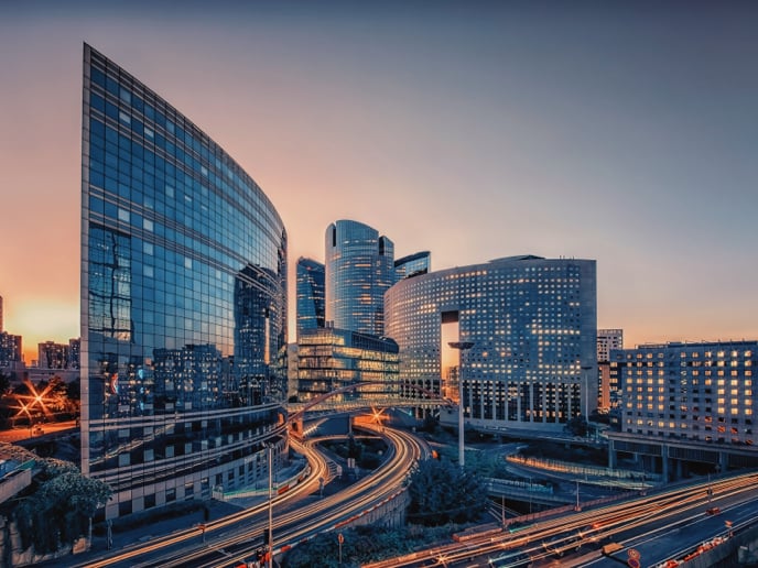 Business district of Paris, France with car-filled roads at sunset.