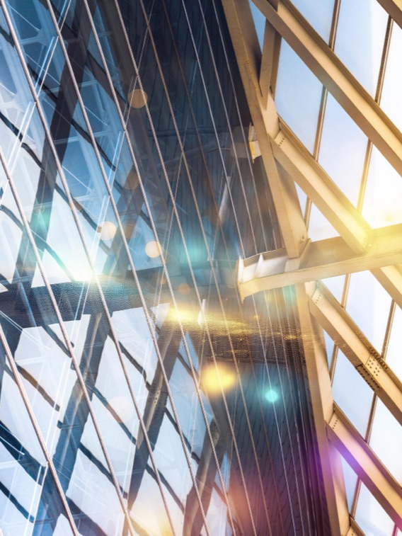 This image is a dynamic, high-angle architectural photograph capturing the intricate internal framework and glass facade of a modern skyscraper. It prominently features the Leeza SOHO tower in Beijing, China, known for its unique "twisting" central atrium.
