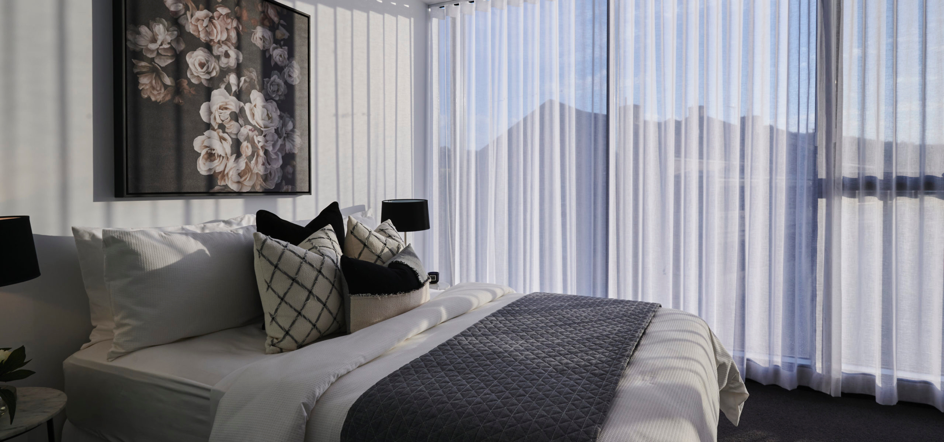 A bed with pillows and a painting on the wall.
